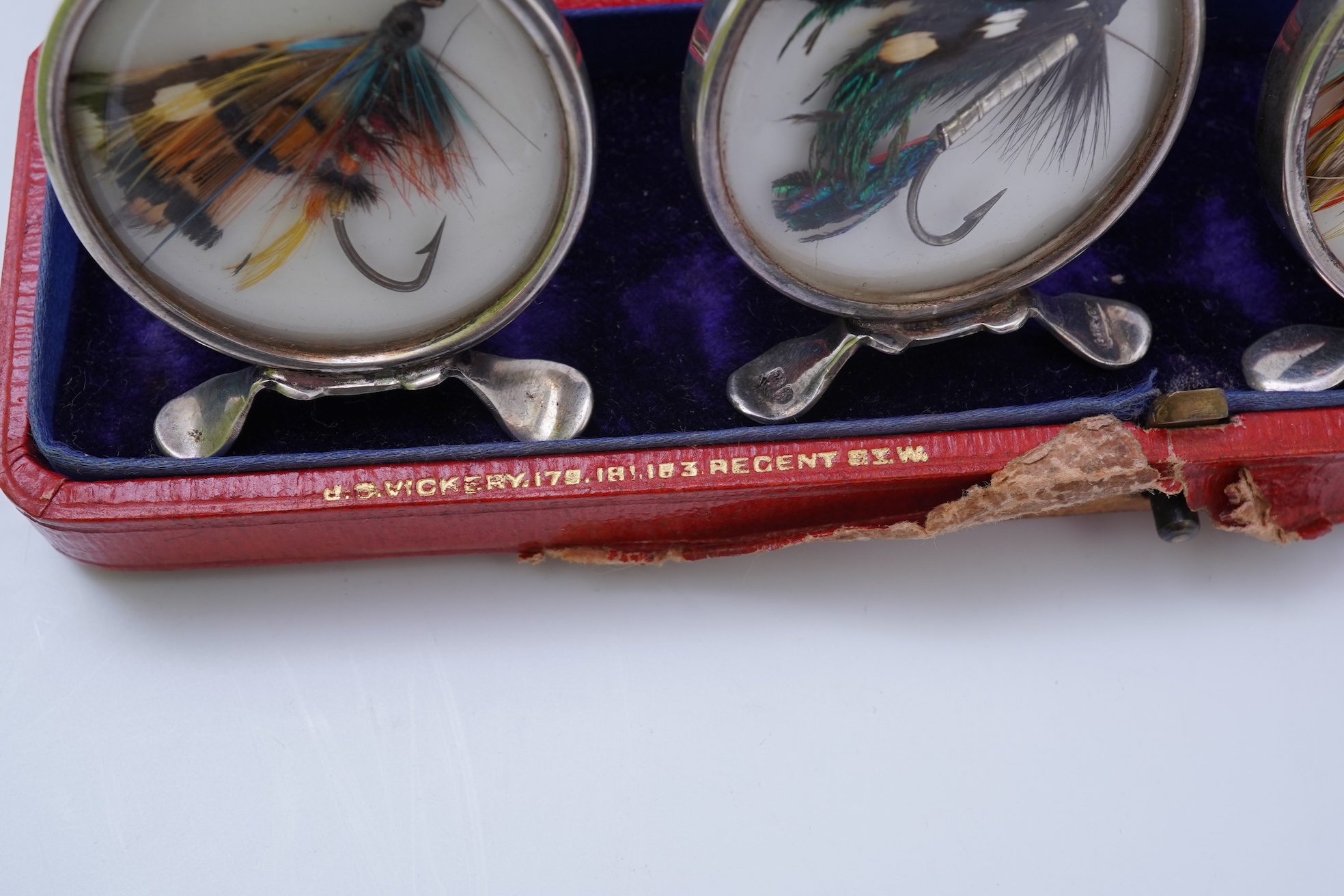 A set of four early 20th century silver mounted fishing related novelty menu holders, by Grey & Co, housed in a red leather case with gilt initials RV